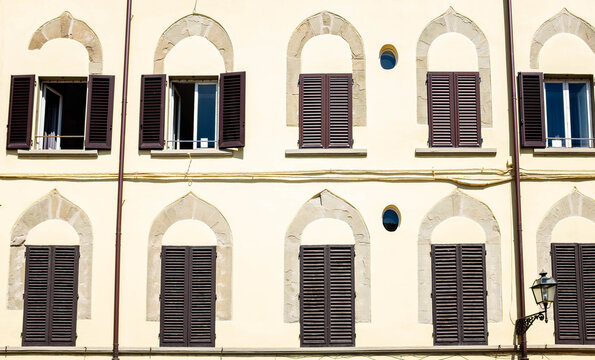 Historic Palace Facade with Renaissance Arched Windows and Wooden Shutters in Florence Italy