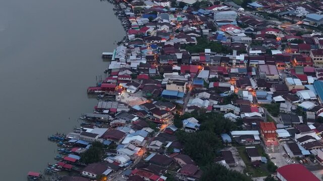 Night aerial footage showing dense riverside housing and docked fishing boats in Sungai Udang village.