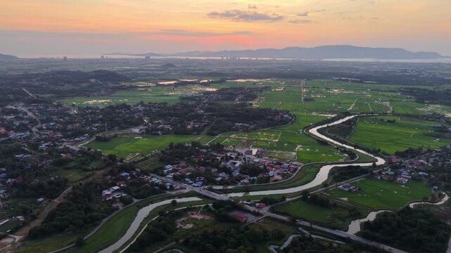 Aerial view of Kubang Semang village, rivers and rice paddies at sunset.