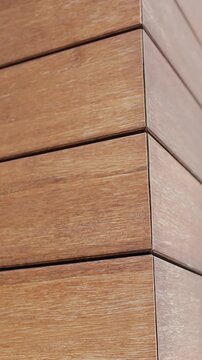 Vertical video. Close-up of modern wooden wall panels with natural texture and clean lines.