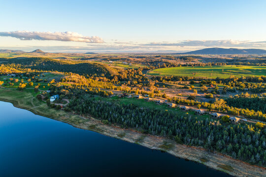 Aerial scene showcasing the Lake Keepit shoreline, sailing club and glamping tents, surrounded by tranquil waters and a picturesque rural landscape in NSW, Australia.