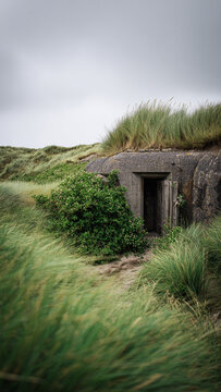 Entrance to an old abandoned secret military bunker from World War II on the Normandy coast among the dunes.