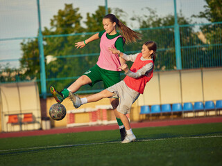 Teenage female soccer players fighting for ball during competitive match. Concept of one on one challenge, defensive pressure, ball control and youth football training. © master1305