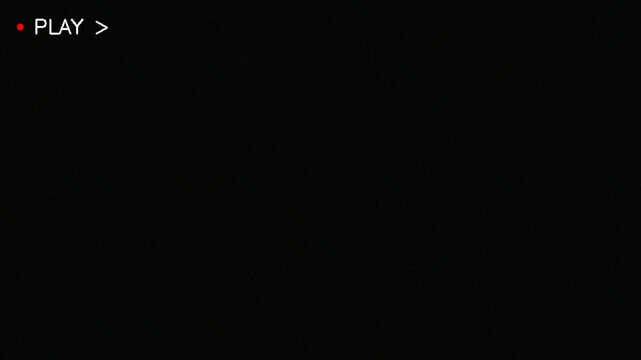 Retro VHS tape recording indicator with play symbol and red light.