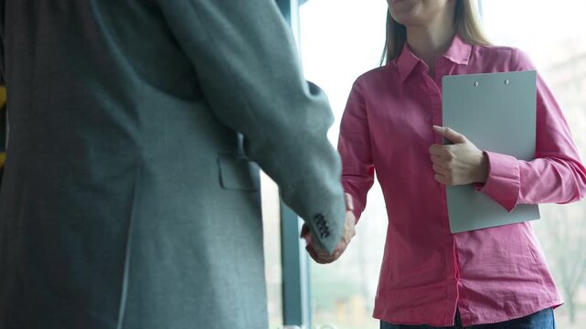 Handshake, greeting and meeting for people in office, welcome or business partners in bank for loan. Finance, startup and women with man for negotiation, lender and assessment of application or funds