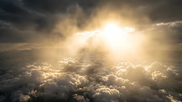 Aerial view of sun rays breaking through dramatic clouds over a sea of fluffy clouds. Heavenly nature, divine sunlight, and majestic weather phenomenon concept.