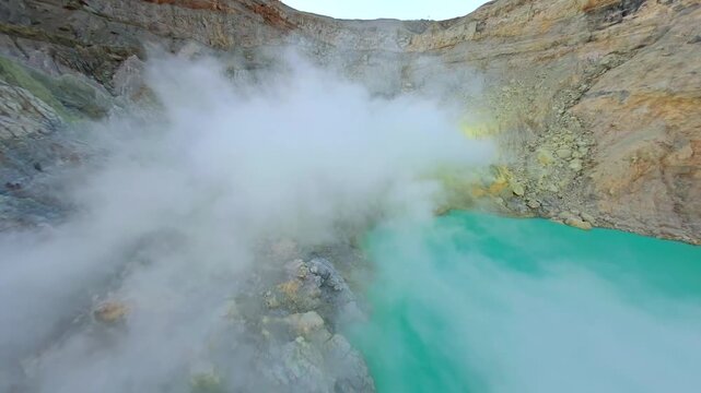 Cinematic FPV drone flight over Kawah Ijen crater with turquoise acidic crater lake and steaming sulfur vents at sunrise in East Java, Indonesia. Dramatic volcanic landscape in Southeast Asia.