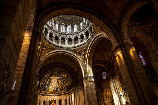 Interior view of Sacre-Coeur Basilica in Montmartre, Paris, showcasing its stunning architecture and intricate mosaics under a grand dome.