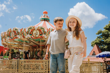 happy boy and girl on a carousel at an amusement park in the summer © Tina kids photo