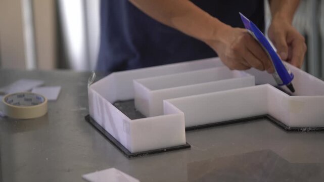 Applying Silicone Adhesive to Install Acrylic Letters on Signage Panel