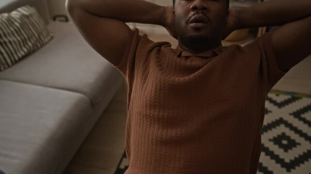 Tilt up shot of young Black man closing tablet computer and leaning back with hands behind head, resting. Clip is ideal for corporate wellness and remote work concepts
