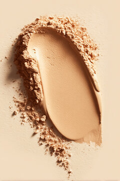 Cosmetic powder and liquid foundation swatch creating a textured beige makeup background, showing skincare beauty and fashion