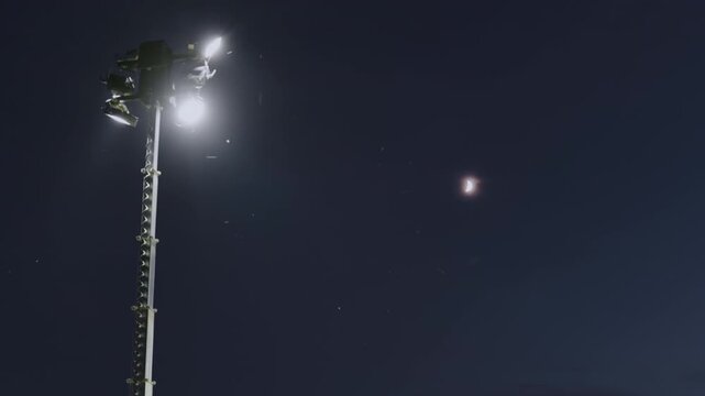Low Angle View of Lighthouse with Floodlights in Night Sky