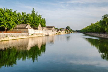 Fototapeta premium The moat surrounding the Forbidden City, known as the Tongzi River, in Beijing, China. It features the historic outer wall on the right side of the water. Traditional architecture along the banks.