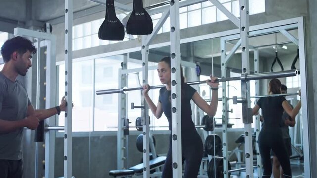 Fitness coach guiding individual on proper weight lifting methods in contemporary gym environment
