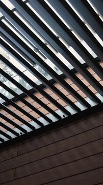 Vertical video. Modern black terrace roof with slatted design overlooking nature.