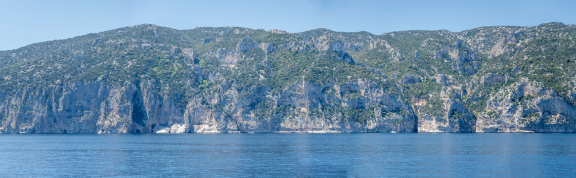 Onamarra peak steep rocky slopes on Mediterranean shore, south of Cala Gonone, Italy