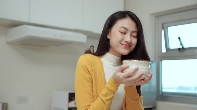 Happy woman enjoying the aroma of green matcha tea in a traditional Japanese cup. smiling female living peaceful relaxation with mindful wellness ritual and self-care moment healthy lifestyle.
