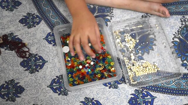 Child counting and playing with crystal beads and pearls, creativity, sensory play, imagination, and learning through play concept