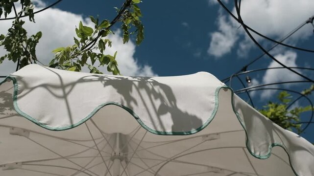 White canvas patio umbrella or parasol. For social media reels, stories, or mobile-first advertising centered on luxury travel, backyard relaxation, resort living, and summer vacations.