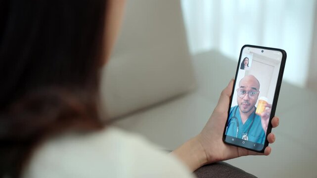 Woman holding smartphone with doctor on video consultation providing virtual medical advice telemedicine for remote healthcare, digital health and online remote patient care technology at home.
