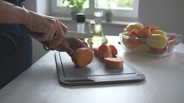 Woman Cutting Raw Sweet Potato In A Close-Up Shot In Home Kitchen