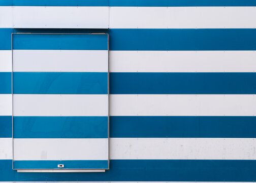 Minimalist flat lay abstract graphic background composed of horizontal blue and white siding stripes with a matching service hatch panel.