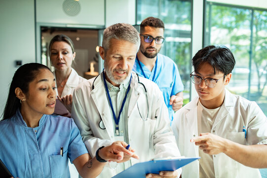 Doctors and nurses discussing patient chart in hospital hallway