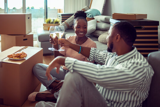 Happy couple toasting champagne while moving into new home