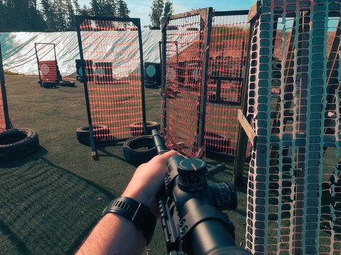 First person view of a shooter aiming with semi automatic carbine rifle at targets during dynamic practical shooting sport competition outdoor