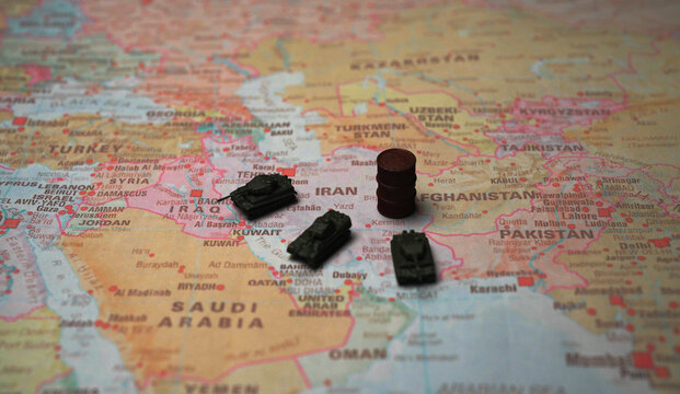 Miniature tanks and oil barrel on Iran map conflict concept.