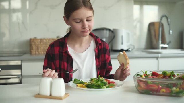 Teen Girl Eating Veggie Salad At Home In The Kitchen