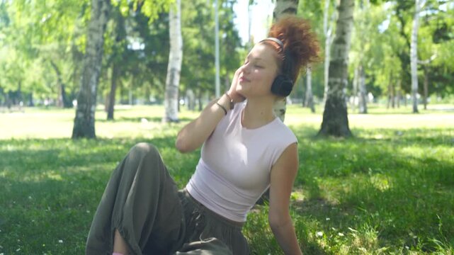 Young woman listening to music on a headphones in the park
