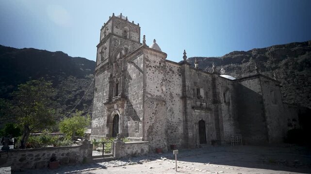 View the San Javier Mission church located between mountains and an oasis near Loreto, Baja California. It offers stunning desert views.