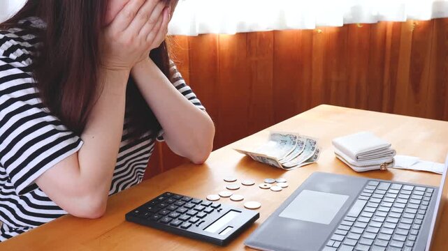 手持ちの現金を数えて絶望する女性
