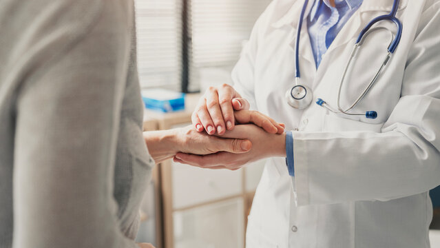 Compassionate doctor comforting patient during consultation