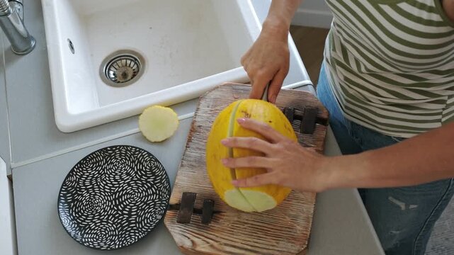 Woman Cutting Melon In Half Top View Close-Up