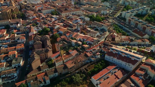 Top down drone view over a compact residential district revealing densely packed buildings narrow streets and varied rooftops in Spain.