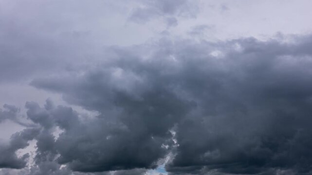 Dark storm clouds move quickly across the sky in an accelerated time-lapse sequence showing turbulent weather changes. Concept of climate change, impending danger, and atmospheric power.