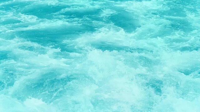 super slow motion of real wild water texture, close-up and high angle view of splashing flowing water with white foam in sunshine