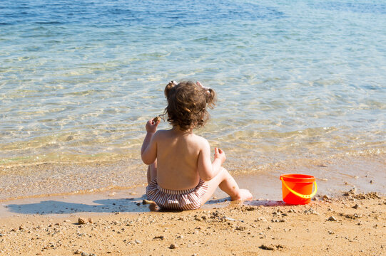 Toddler Sitting on a Sandy Adriatic Beach, Enjoying Summer by the Sea in Croatia