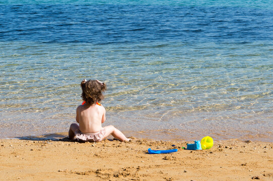 Toddler Sitting on a Sandy Adriatic Beach, Enjoying Summer by the Sea in Croatia