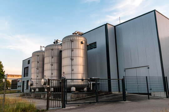Modern power to heat industrial facility with large stainless steel storage tanks, local microgrid thermal energy storage concept in Germany.
