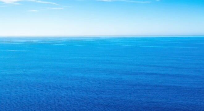 Expansive view of the deep blue ocean stretching endlessly toward the distant horizon under a bright sunny sky, conveying vastness, outdoor, natural, distance