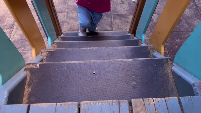 Child walking down playground stairs developing motor skills