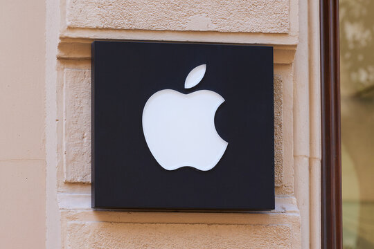 Apple company logo sign mounted on store exterior wall. Valencia, Spain - March 19, 2023.