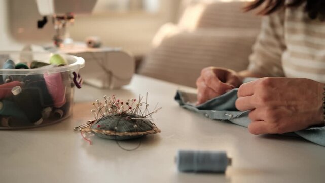 Close-Up Of A Woman Pinning Fabric Before Setting Up A Sewing Machine