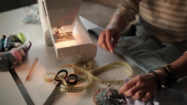 Woman Pinning Edge Of Fabric For Home Sewing