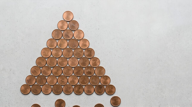 Triangle shape made of copper coins on a textured light gray background