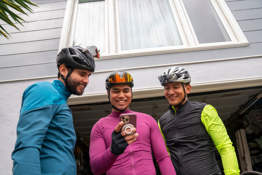 Group of three cyclist looking at smartphone preparing for activity